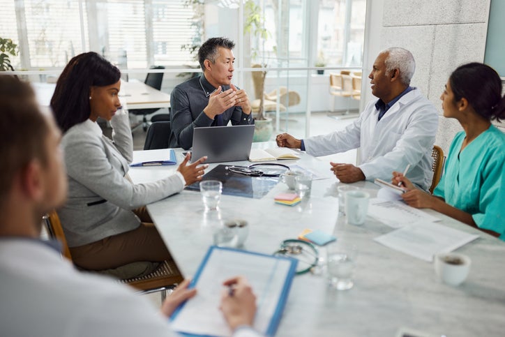 picture of people of varied races and professions sitting around a table