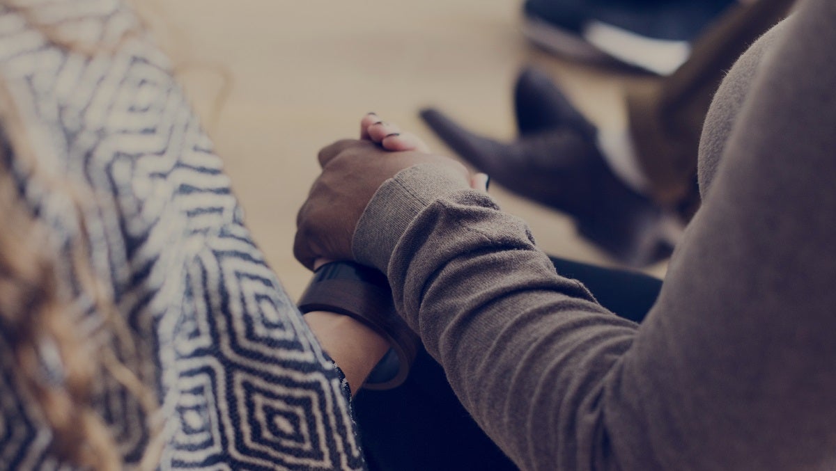 Two people holding hands during counseling session
